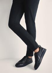 Czarne skórzane sneakersy męskie BUTYM-0465-99(Z25), widok produktu na stopach modela na jasnym tle.