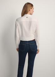 Biała koszula damska KOSDT-0180-0P(W26), widok produktu z tyłu na modelce. Widoczna połowa sylwetki.