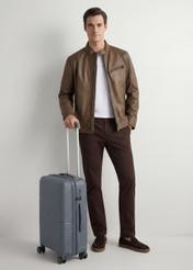 Walizka mała na kółkach WALPP-0021-9B-19(W26), widok produktu skosem obok sylwetki modela.