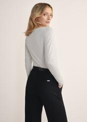 Beżowa bluzka damska z długim rękawem LSLDT-0038-81(KS), widok produktu od tyłu na modelce, widoczna połowa sylwetki.