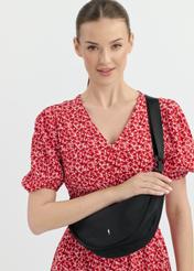Czarna półokrągła torebka na ramię TOREN-0315-99(W25), widok przodu produktu na modelce. Widoczna połowa sylwetki.