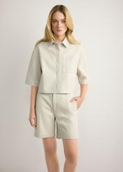 Skórzane kremowe szorty damskie SPODS-0047-0B(W26), widok produktu z przodu na modelce. Widoczna połowa sylwetki.