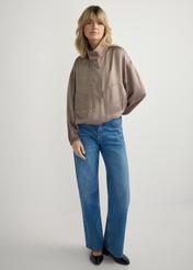 Lekka beżowa bomberka damska KURDT-0627-1K(W26) - widok produktu z przodu na modelce, na jasnym tle. Widoczna cała sylwetka. 