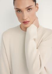 Beżowa sukienka damska SUKDT-0260-1A(W26), zbliżenie na produkt na modelce.