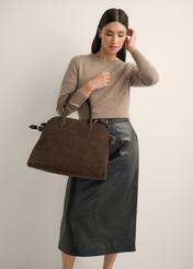 Ciemnobrązowa skórzana torebka damska typu shopper TORES-1412-1H(Z26) - widok torebki lekko po skosie, trzymanej przez modelkę w ręku, na jasnym tle. Widoczna sylwetka do kolan. 