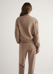 Bluza damska w kolorze camelu BLZDT-0121-1D(W26), widok produktu z tyłu na modelce. Widoczna połowa sylwetki.