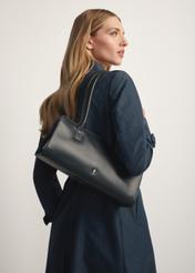 Czarna skórzana podłużna torebka damska TORES-1259-99(W26) - widok produktu po skosie, na modelce, na białym tle. 