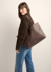 Brązowa groszkowana torebka shopper TOREC-1252-1I (Z26), widok produktu od przodu na modelce. Widoczna połowa sylwetki.