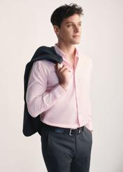Różowa koszula męska KOSMT-0351-34(Z25) - widok produktu z boku na modelu na białym tle. Widoczna sylwetka do kolan. 