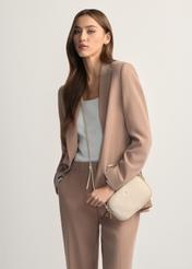 Mała skórzana torebka damska w kolorze kremowym TORES-1152-0B(W26), widok produktu od przodu na modelce, widoczna połowa sylwetki.