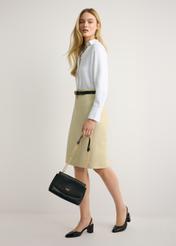 Czarna listonoszka na łańcuszku TOREC-1152-99(W26) - widok produktu z przodu, trzymanego przez modelkę w ręku, na jasnym tle. Widoczna cała sylwetka. 