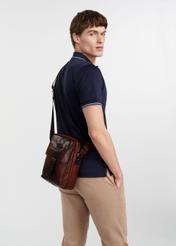 Skórzana brązowa torba męska TORMS-0104-1H(W26), widok produktu z boku na sylwetce modela, na jasnym tle.