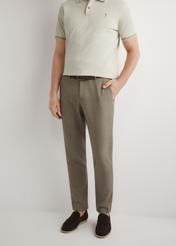 Ciemnobrązowe spodnie garniturowe męskie SPOMT-0098-1I(W26), widok produktu z przodu na modelu. Widoczna połowa sylwetki.