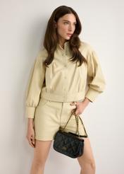 Czarna skórzana lakierowana torebka damska TORES-1297-99(W26), widok produktu w dłoni modelki. Widoczna połowa sylwetki.