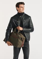 Torba podróżna w kolorze khaki TORMN-0372-55(Z25) - widok produktu na modelu, na białym tle. Widoczna sylwetka do kolan.