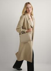 Beżowa skórzana torebka damska na ramię TORES-0983E-1B(W26), widok produktu na ramieniu modelki. WIdoczna cała sylwetka.