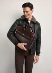Brązowa skórzana torba męska TORMS-0483-89(Z25) - widok produktu z przodu, na modelu, na białym tle. Widoczna połowa sylwetki. 