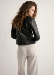 Czarna kurtka damska ze skóry naturalnej KURDS-0154-99(W26) - widok produktu z tyłu, na jasnym tle. Widoczna sylwetka do kolan. 