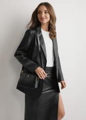 Czarna mała torebka damska TOREC-1126-99(W26), widok produktu od przodu na modelce, widoczna połowa sylwetki.