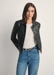 Czarna krótka skórzana kurtka damska KURDS-0598-99(W26), widok produktu od przodem na modelce, widoczna połowa sylwetki.