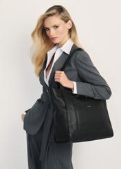 Czarna skórzana torebka damska TORES-1144-99(Z25) - widok z produktu na modelce na białym tle. Widoczna połowa sylwetki.