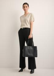 Czarna skórzana torebka shopper TORES-1342-9I(Z26), widok produktu w dłoni modelki. Widoczna cała sylwetka.