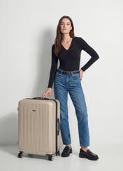 Walizka duża na kółkach WALAB-0053-0X-29(W26), widok produktu skosem obok sylwetki modelki.