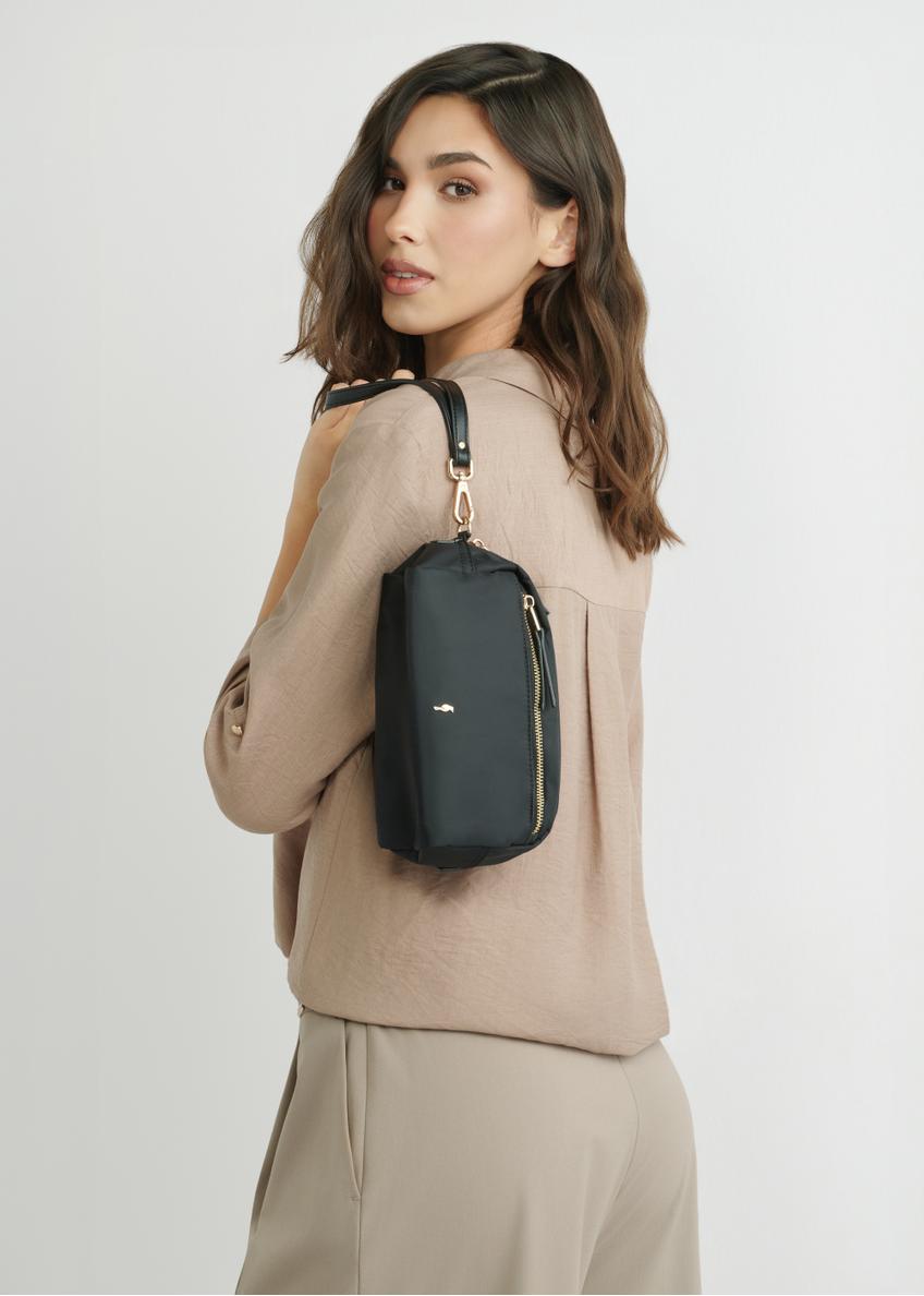 Czarna kosmetyczka damska TOREN-0347-99(W26), widok produktu na sylwetce modelki, na jasnym tle.