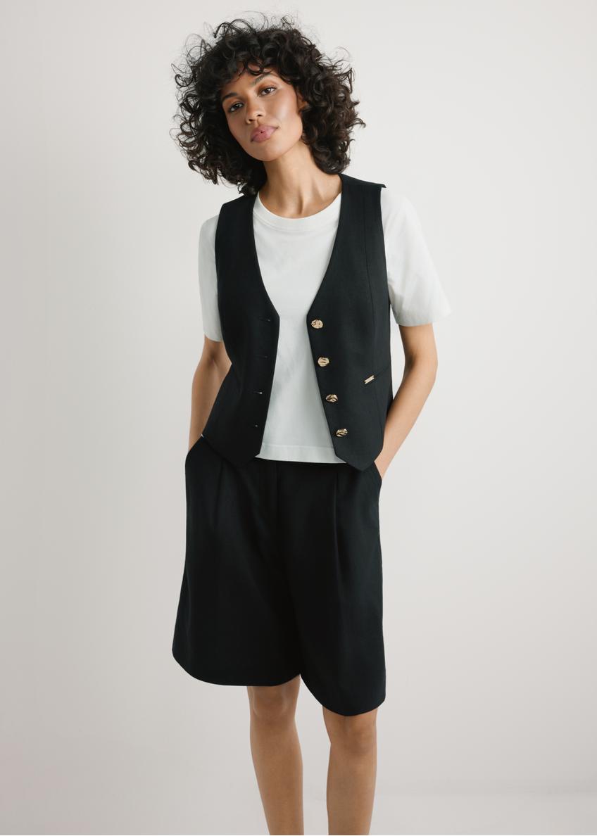 Czarna kamizelka z wiskozy i lnu KAMDT-0038-99(W26) - widok produktu z przodu, na modelce, na jasnym tle, Widoczna sylwetka do kolan. 