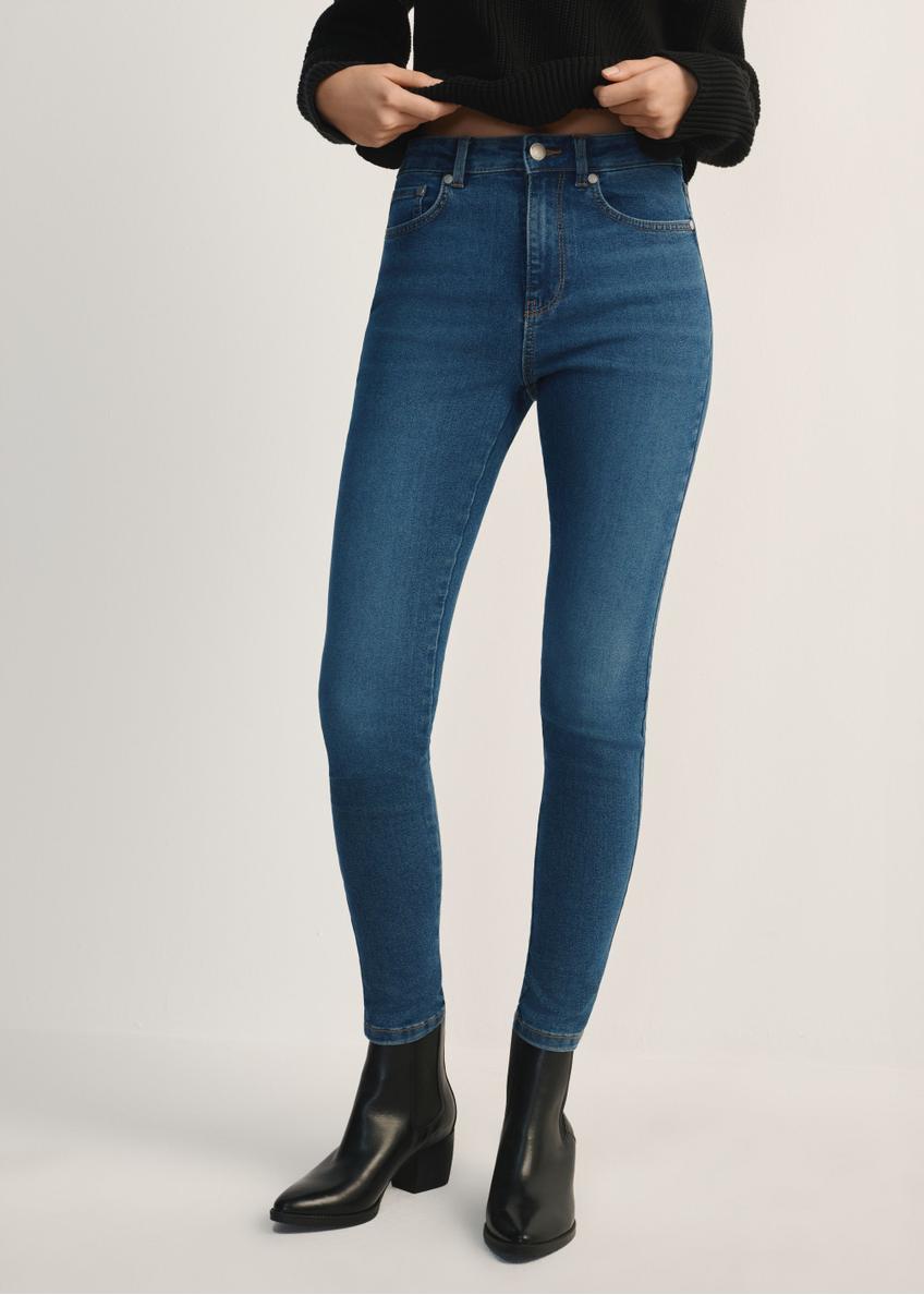Niebieskie jeansowe spodnie damskie JEADT-0010A-7B(Z26) - widok produktu od przodu na modelce, widoczna połowa sylwetki.