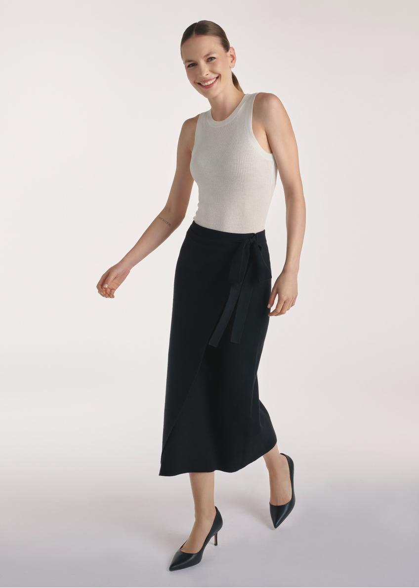 Czarna spódnica midi SPCDT-0114-99(Z25), widok produktu z przodu na modelce, widoczna cała sylwetka.