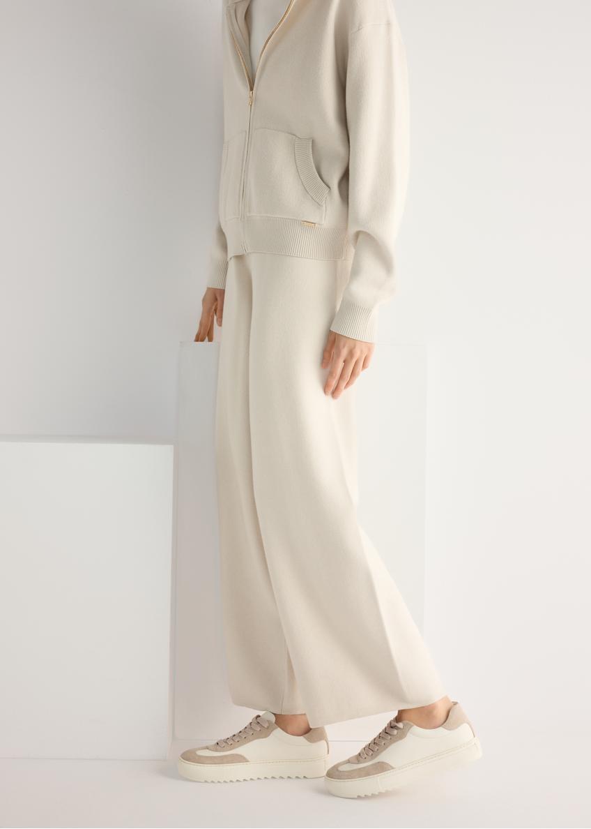 Skórzane tenisówki damskie w kolorze kremowym BUTYD-1260-0B(W26), widok produktu od boku na modelce, widoczna połowa sylwetki.