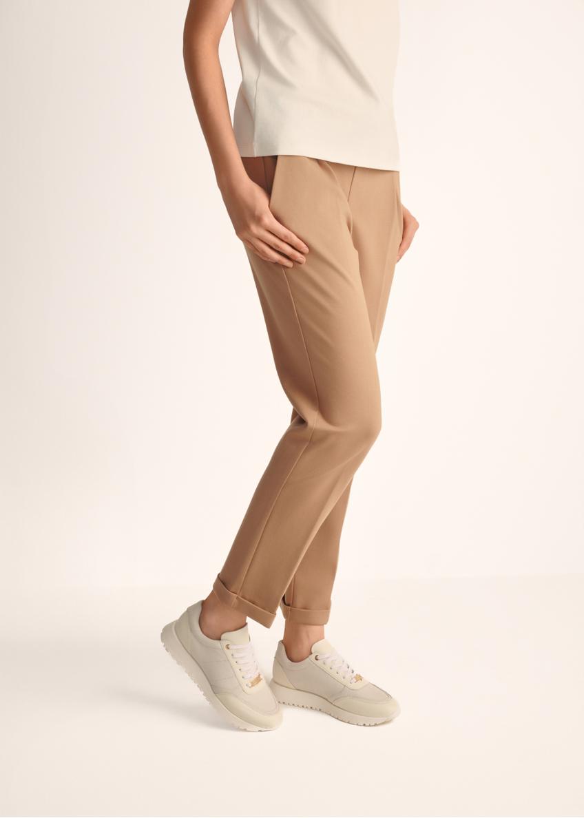 Kremowe skórzane buty sportowe damskie BUTYD-1099-11(Z25), widok produktu na stopach modelki na jasnym tle.