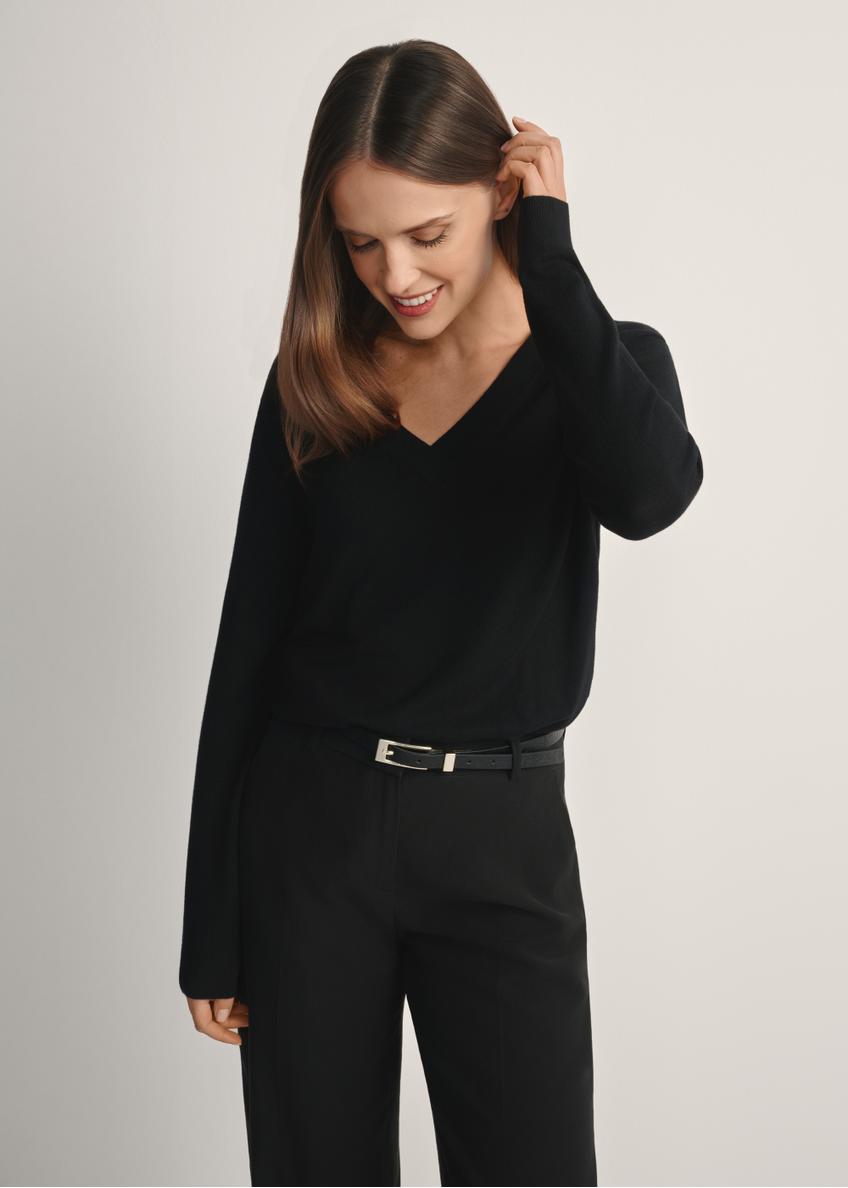 Czarny sweter z dekoltem V-neck SWEDT-0201-99(W24), widok produktu od przodu na modelce, widoczna połowa sylwetki.