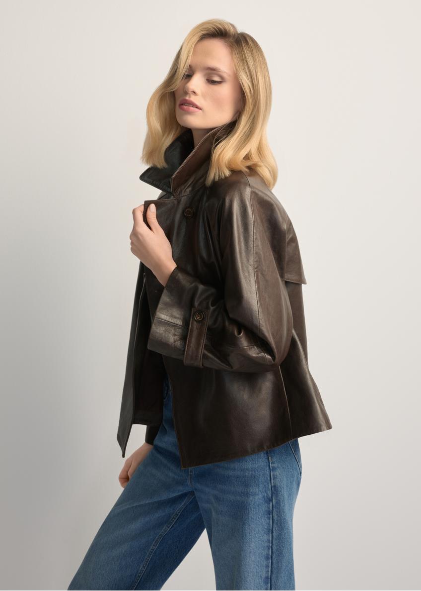 Skórzana kurtka damska w kolorze ciemnobrązowym KURDS-0604-1I(W26), widok produktu z boku na modelce. Widoczna połowa sylwetki.