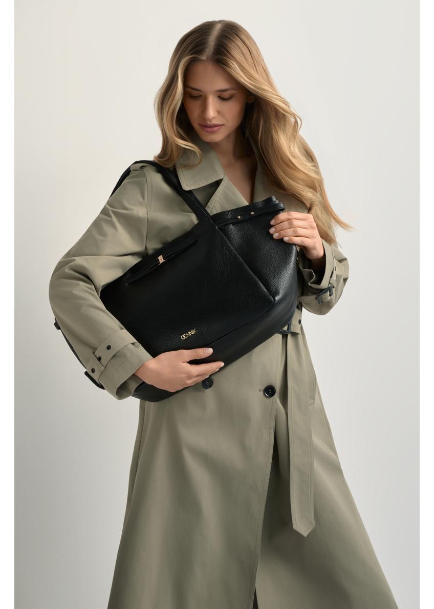 Skórzana torebka shopper w kolorze czarnym TORES-1207-9I(W26) - widok produktu z przodu, na modelce, na jasnym tle. Widoczna sylwetka do kolan.