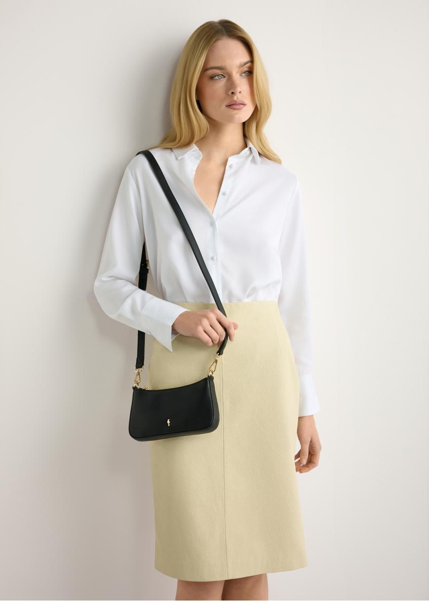 Mała czarna torebka damska TOREC-1188-99(W26) - widok produktu z przodu, na modelce, na jasnym tle. Widczona sylwetka do połowy. 