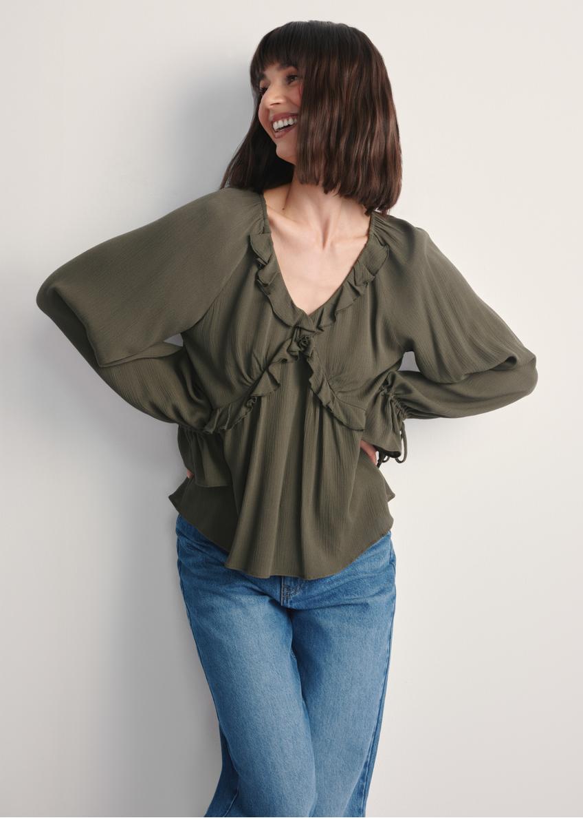Bluzka damska w kolorze khaki BLUDT-0194-55(Z25), widok produktu przodem na modelce, widoczna połowa sylwetki.
