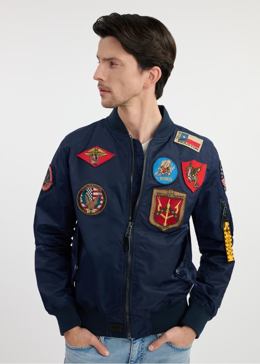 Granatowa męska kurtka pilotka TOP GUN KURMT-0381-69(W25) - widok z przodu na modelu na białym tle. Widoczna połowa sylwetki. 