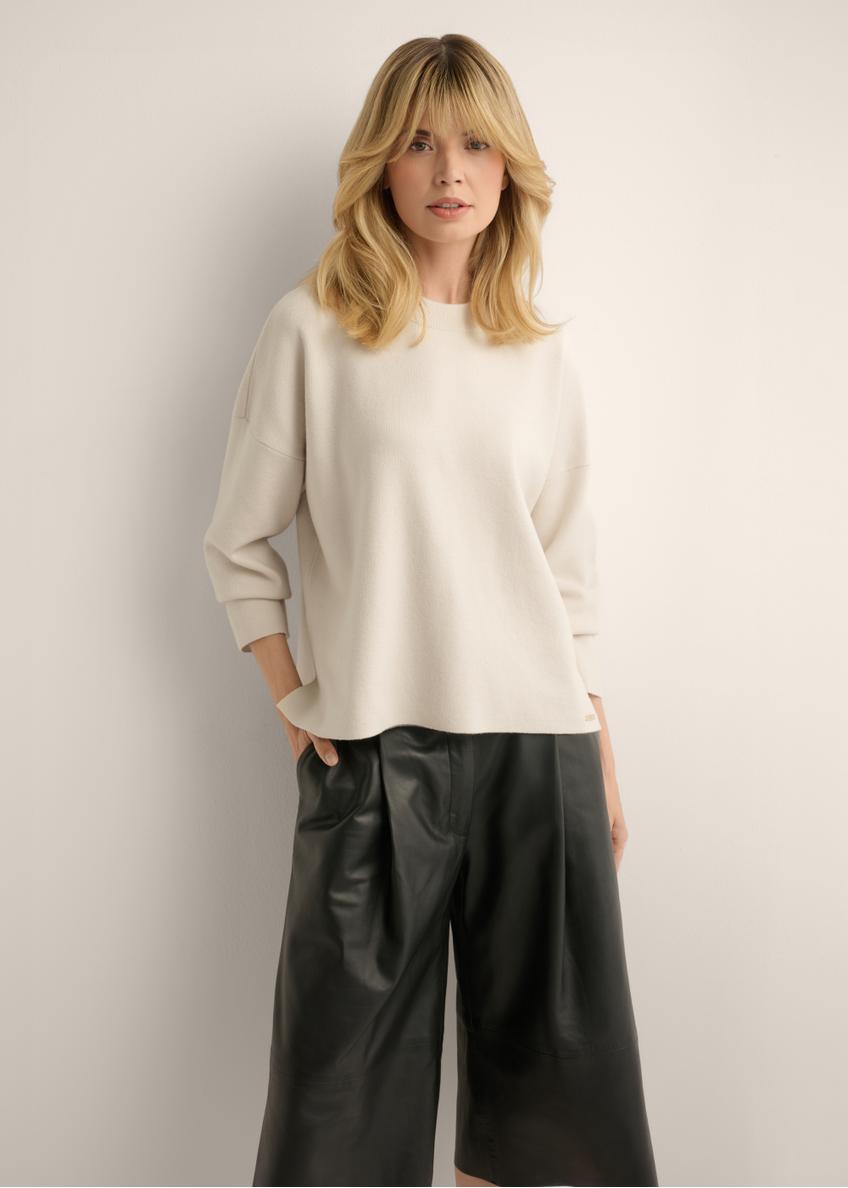 Jasnobeżowy sweter damski SWEDT-0263-1A(Z26), widok produktu z przodu na modelce. Widoczna połowa sylwetki.