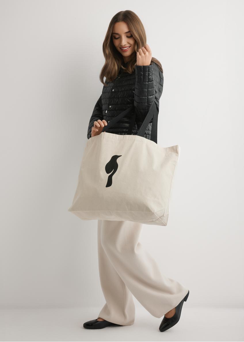 Kremowa bawełniana torba TOREN-0136-0C(W26), widok produktu na ramieniu modelki. Widoczna cała sylwetka.