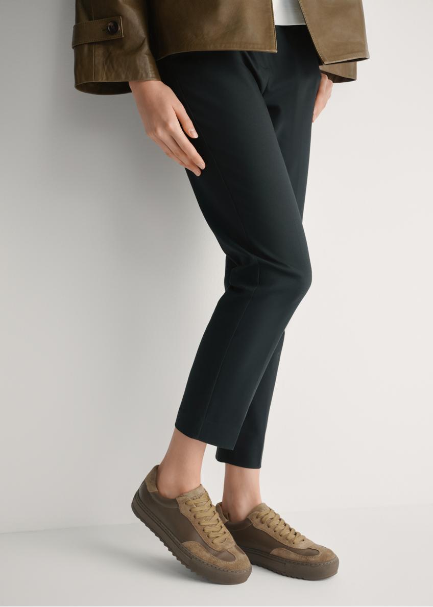 Skórzane tenisówki damskie w kolorze chłodnego beżu BUTYD-1260-1K(W26), widok produktu z boku na stopach modelki.