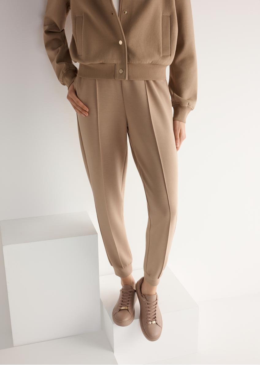 Różowe skórzane tenisówki damskie BUTYD-1068-5D(W26), widok produktu od przodu na modelce, widoczna połowa sylwetki.