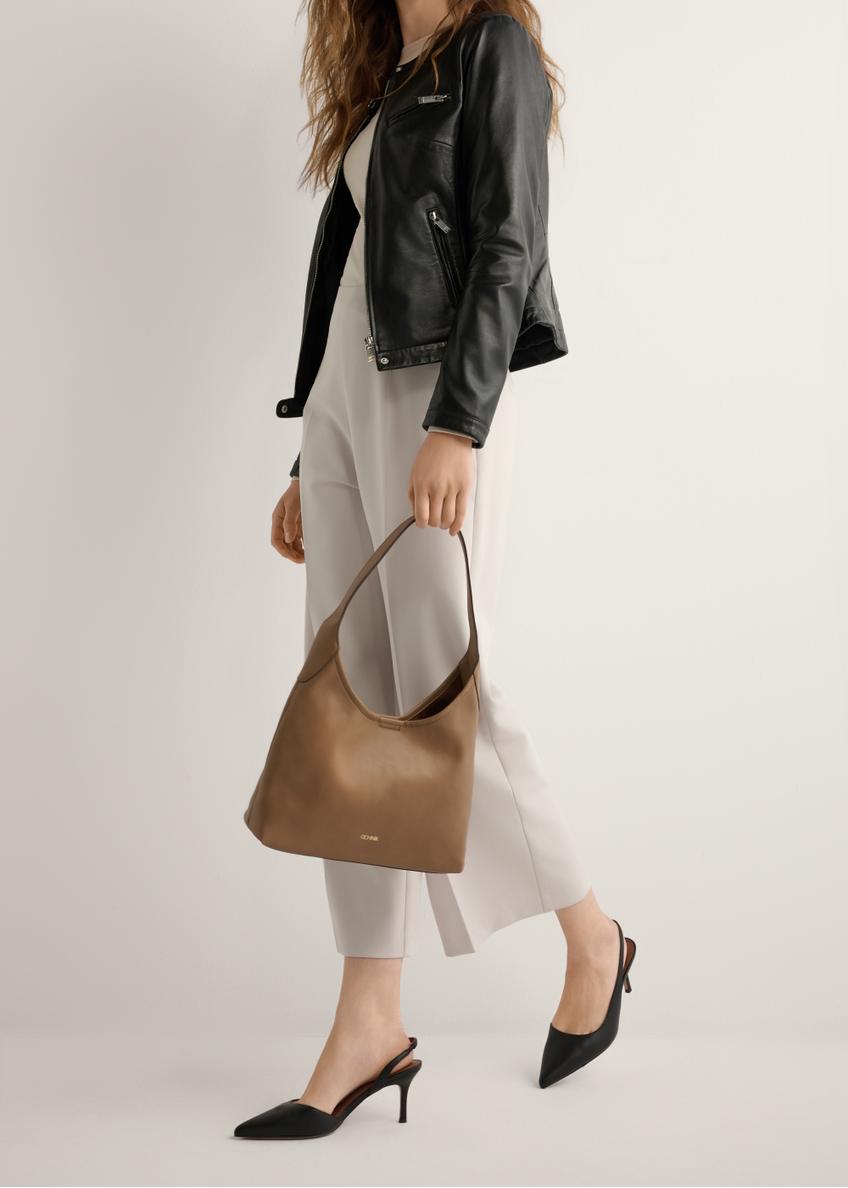 Czarne skórzane czółenka z wyciętą piętą BUTYD-1078A-99(W26), widok produktu z boku na stopach modelki, na jasnym tle.