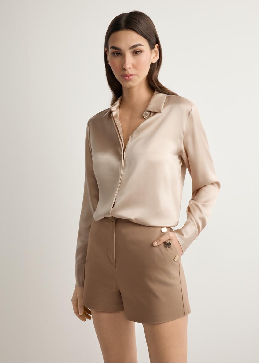 Damskie eleganckie szorty w kolorze camelu SZODT-0018-1D(W26), widok produktu z przodu na modelce. Widoczna połowa sylwetki.