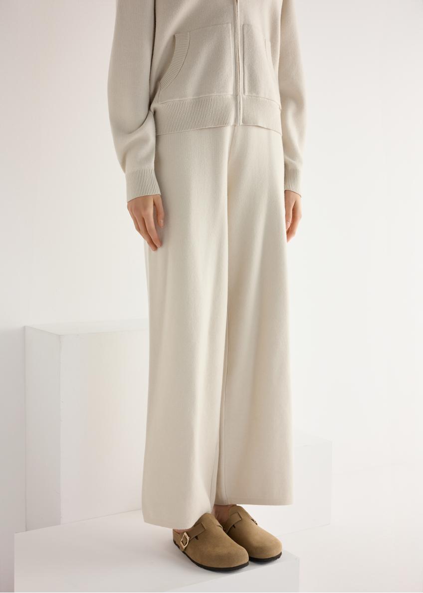 Zamszowe klapki damskie w kolorze chłodnego beżu BUTYD-1267-1K(W26), widok produktu skosem na stopach modelki.