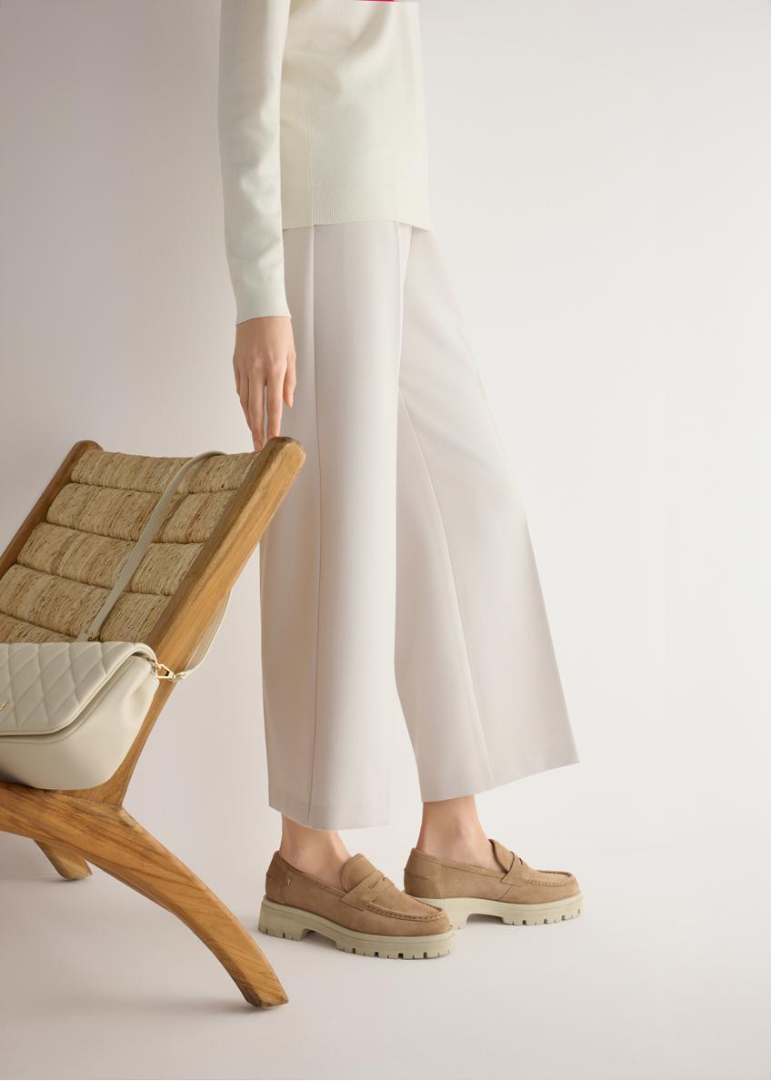 Skórzane mokasyny na platformie w kolorze beżowym BUTYD-1069-1B(W26), widok produktu od boku na modelce, widoczna połowa sylwetki.