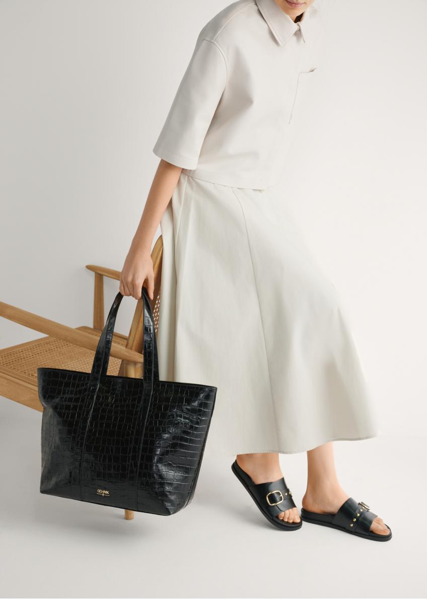 Czarne skórzane klapki damskie BUTYD-1269-99(W26), widok produktu z boku na stopach modelki.