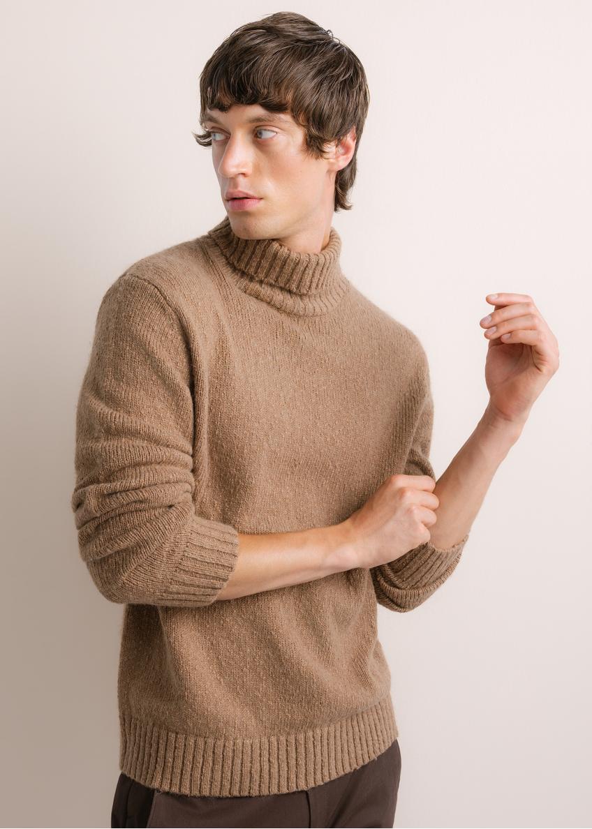 Męski sweter z golfem w kolorze camelowym SWEMT-0209-1D(Z26), widok produktu skosem na modelu. Widoczna połowa sylwetki.