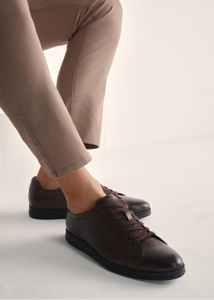 Brązowe skórzane buty męskie BUTYM-0513-89(Z25), widok produktu na stopach modela na jasnym tle.